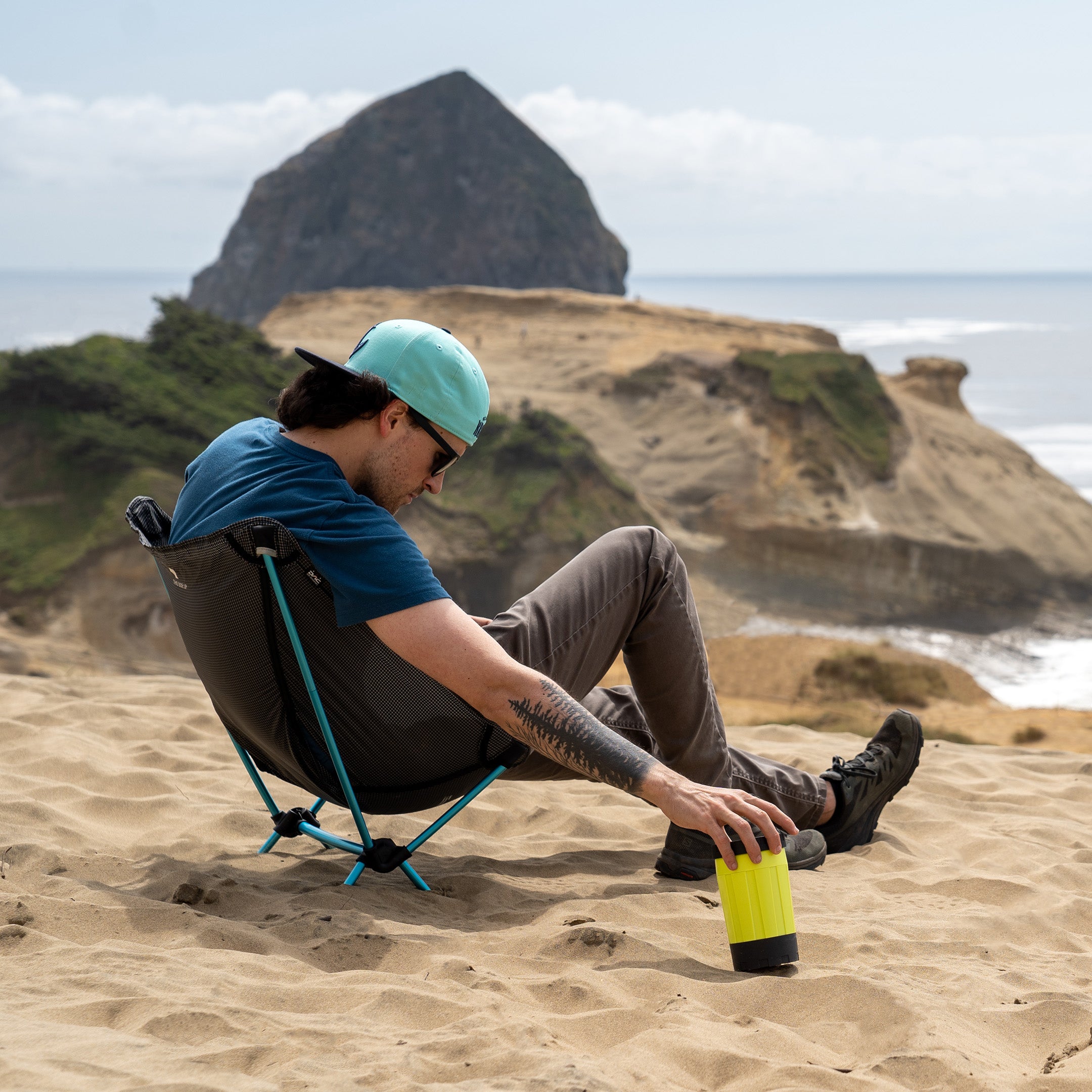 Man on beach cooking with electric camping stove