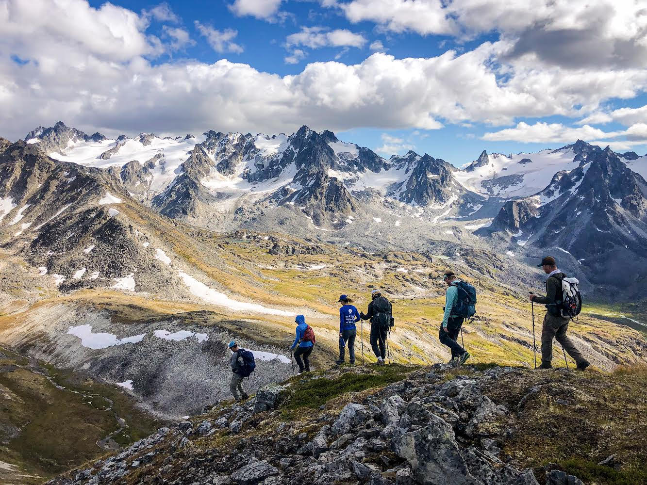 Men and woman backpacking on ridgeline in Alaska