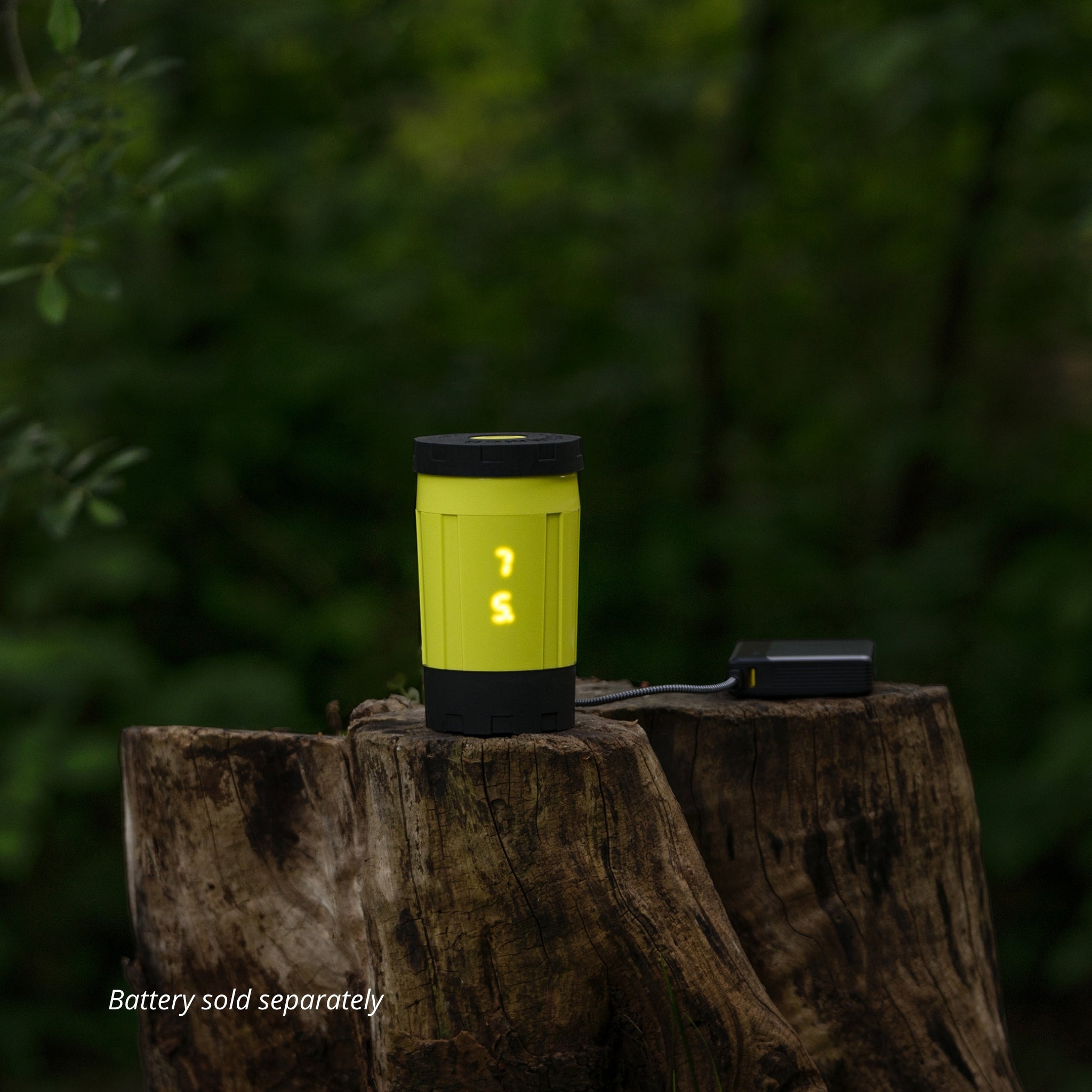 Sustainable flameless electric backpacking stove displaying 75C plugged into USB-C battery on tree stump